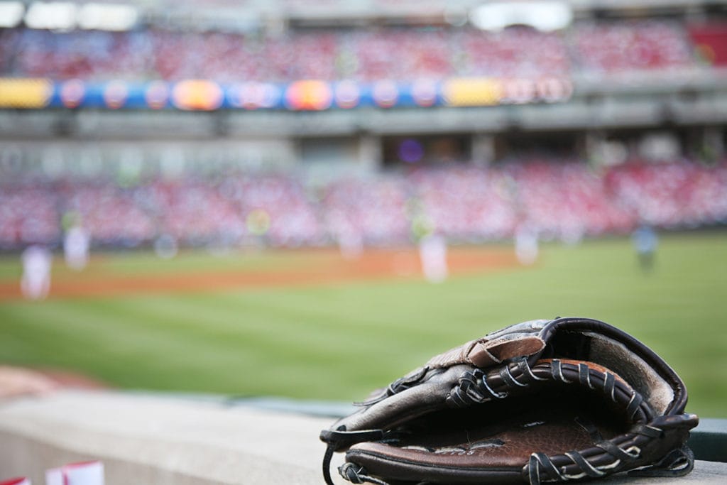 baseball mitt with minor league stadium and field in background