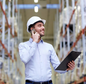 business owner in warehouse speaking to distributor on phone