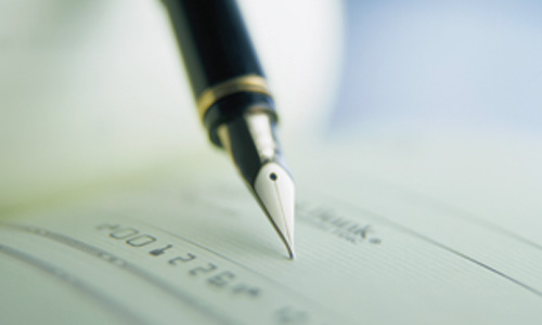 close-up picture of pen filling out a check
